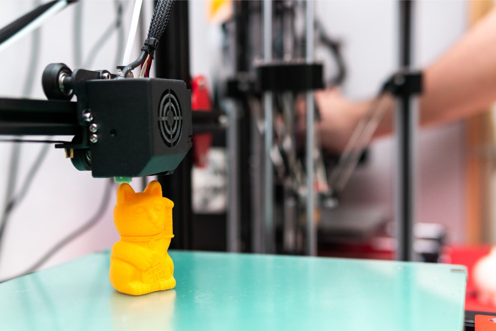 3D-Drucker mit orangefarbener Figur
